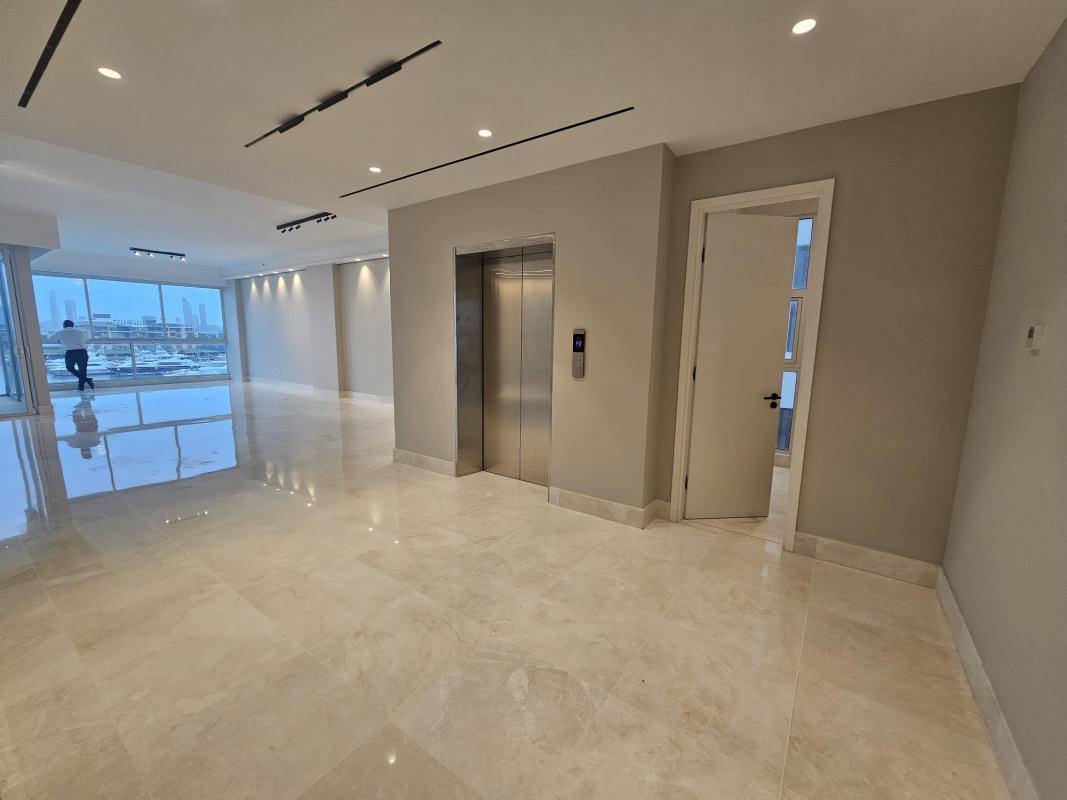 Luxury bedroom with oversized windows, wood floors and view to marina and city skyline in PH Waterfront Panama