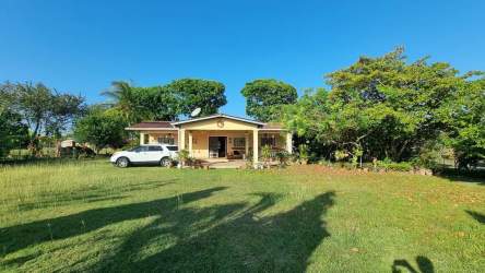 Fenced entrance gate with green garden path and trees at countryside property La Paz Chame