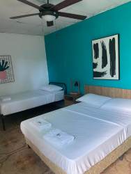 Two single beds with red curtains, minimalist decor Casa del Mar Hotel Pedasi Panama