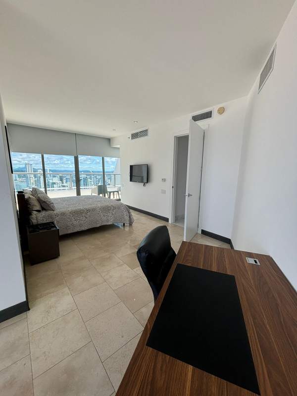 Open living and dining room, marble flooring, contemporary artwork, luxury Punta Pacífica condo