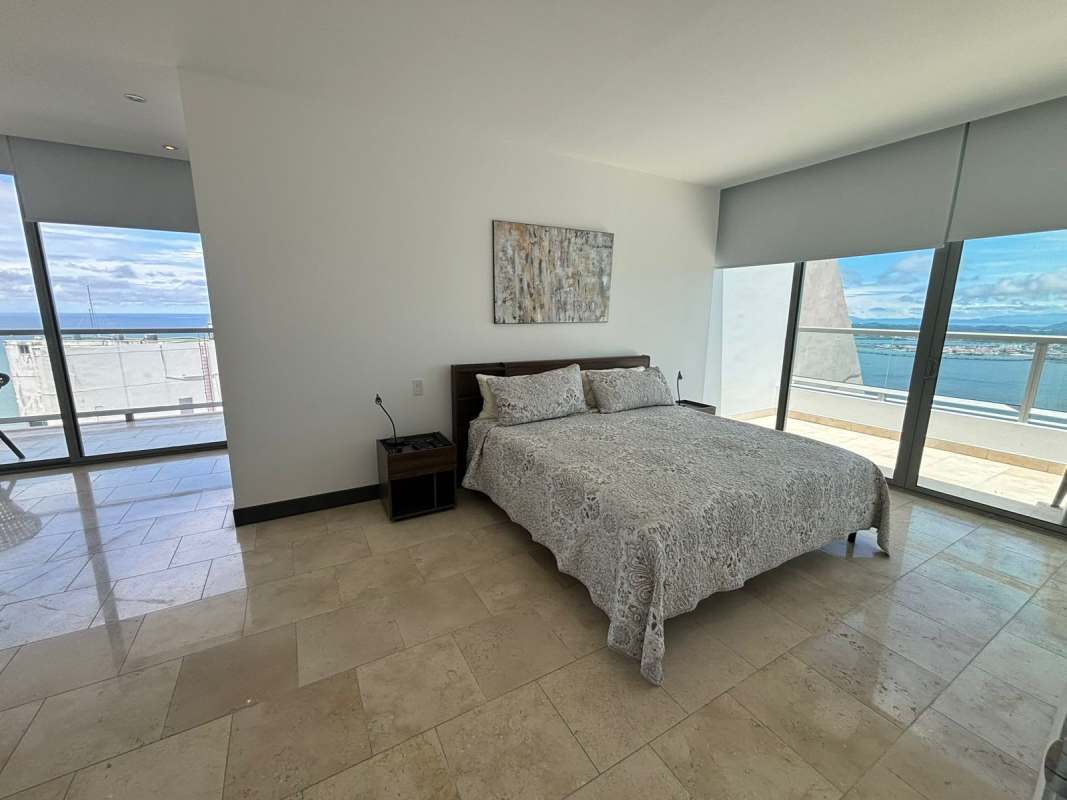 Modern master bedroom with large windows, balcony access, ocean vistas in Punta Pacífica Panama condo