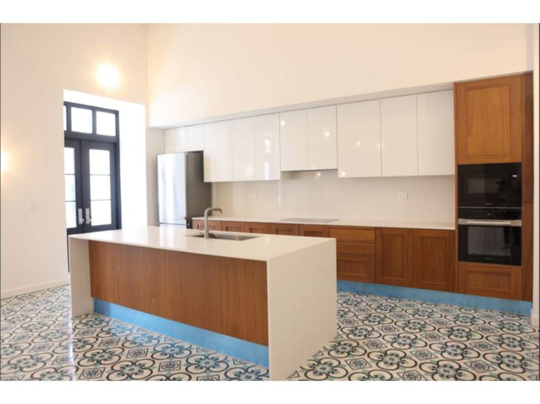 Kitchen with large island, patterned tile, white cabinets, stainless appliances Santa Familia Casco Viejo