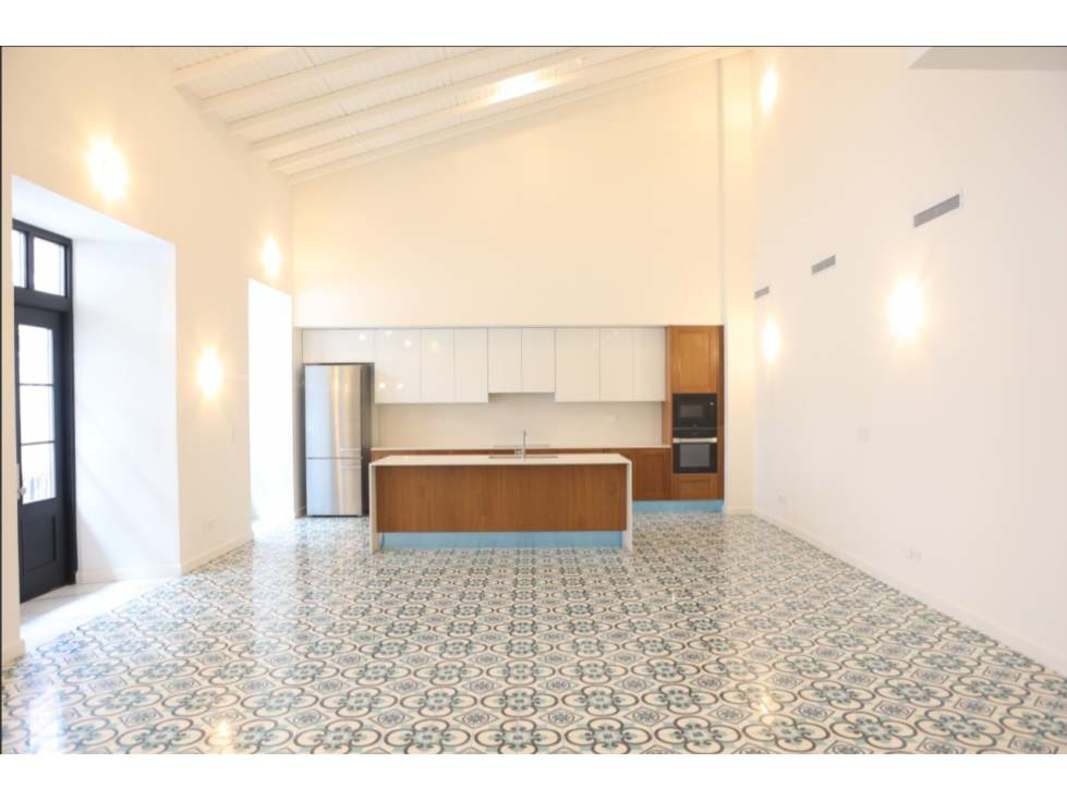 Luxury kitchen island with patterned tile floors, stainless steel fridge, bright Casco Viejo residence