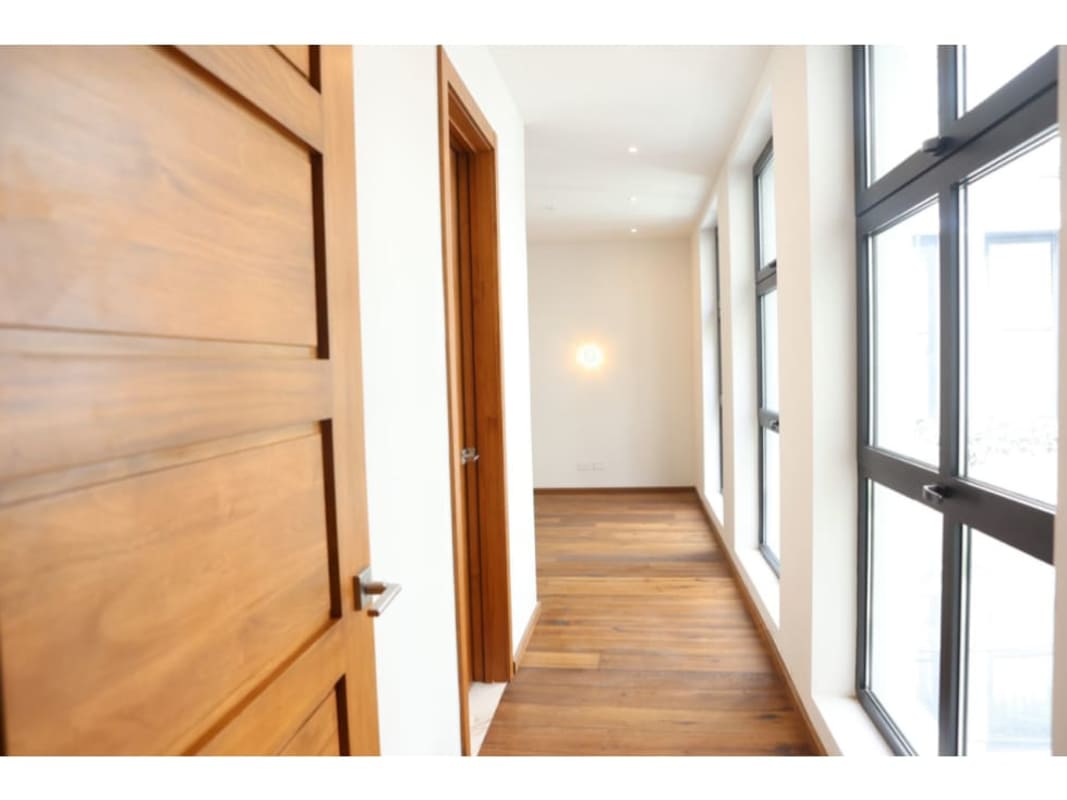 Sunny corridor large windows wood floors lush garden view Santa Familia Casco Viejo