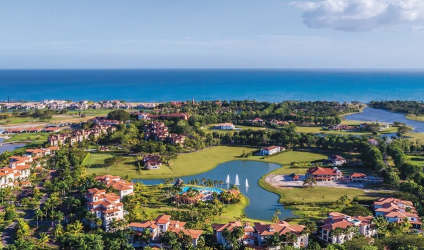 Aerial of lake with beachfront golf course Buena Ventura luxury community and ocean backdrop Panama