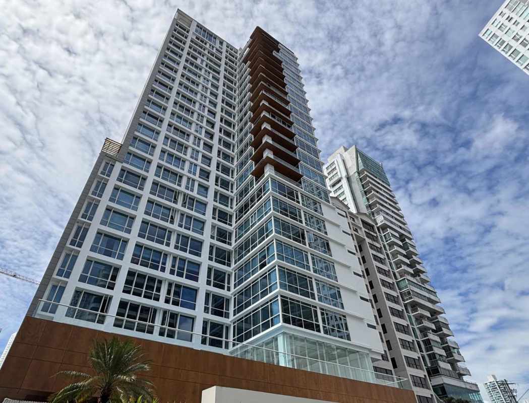 Spacious living room with floor-to-ceiling windows panoramic ocean and skyline views in PH Santorini Panama
