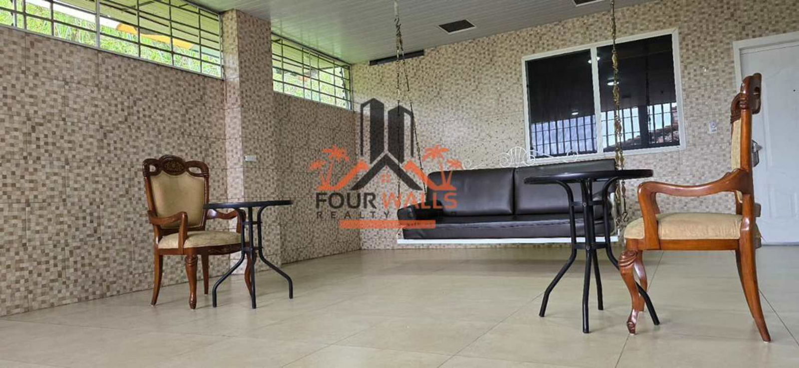 Enclosed balcony sunroom with swing and vintage chairs in PH Altos del Country Panama