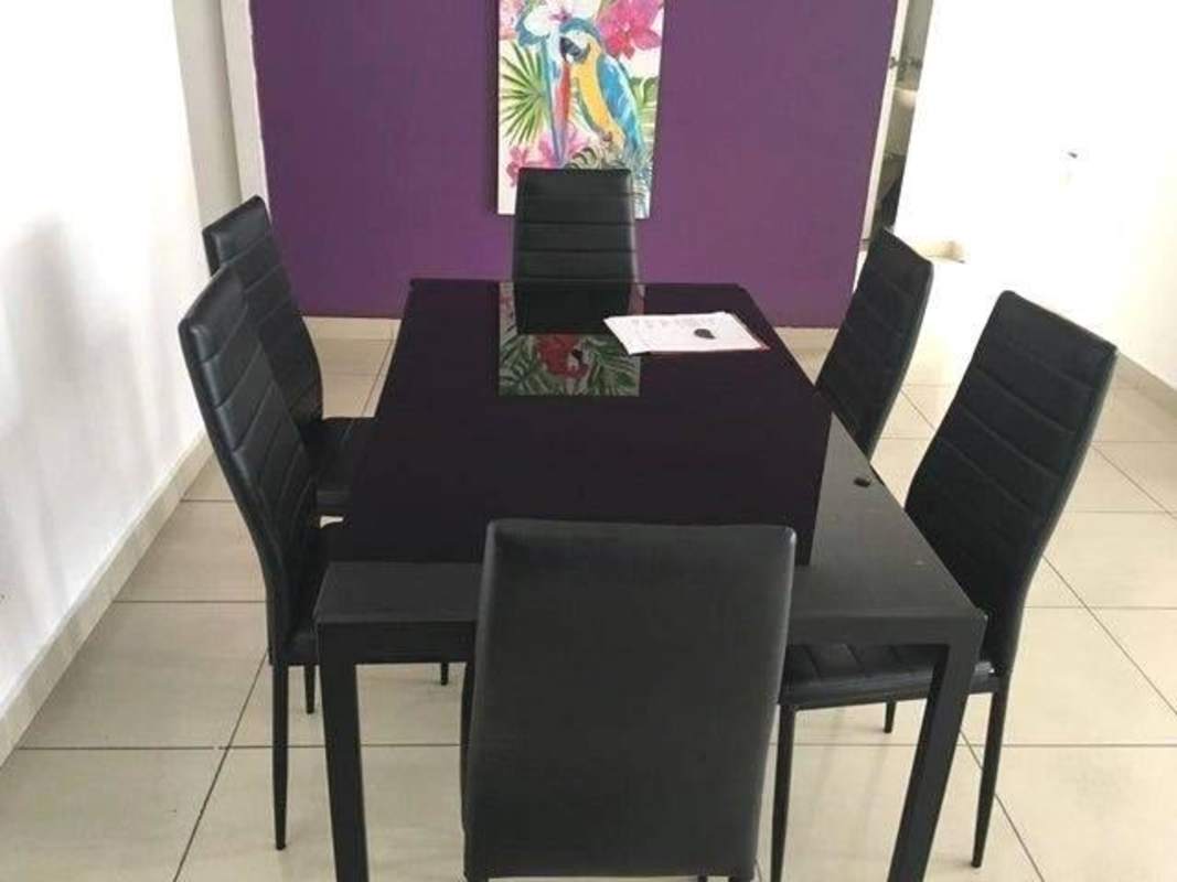 Dining area with black glass table and colorful parrot art in PH San Francisco Bay Panama