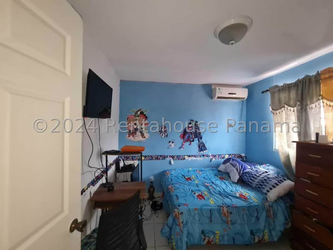 Front entry with ornate metal door, wrought iron railing and carport in Praderas del Rocio residential house Panama