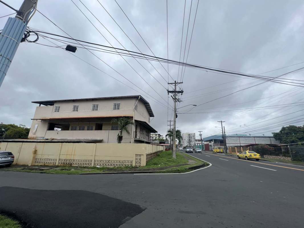 Two-story educational commercial building on corner fenced with palm trees Panama City