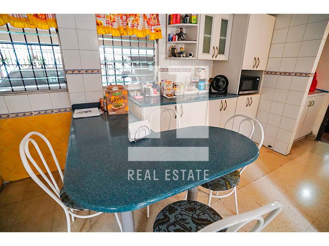 Bright kitchen with blue counters and tile walls in Altos del Golf Panama house