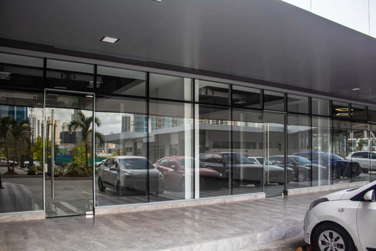 Modern double glass storefront with overhang marble sidewalk and display windows at Sunset Strip Mall Panama City
