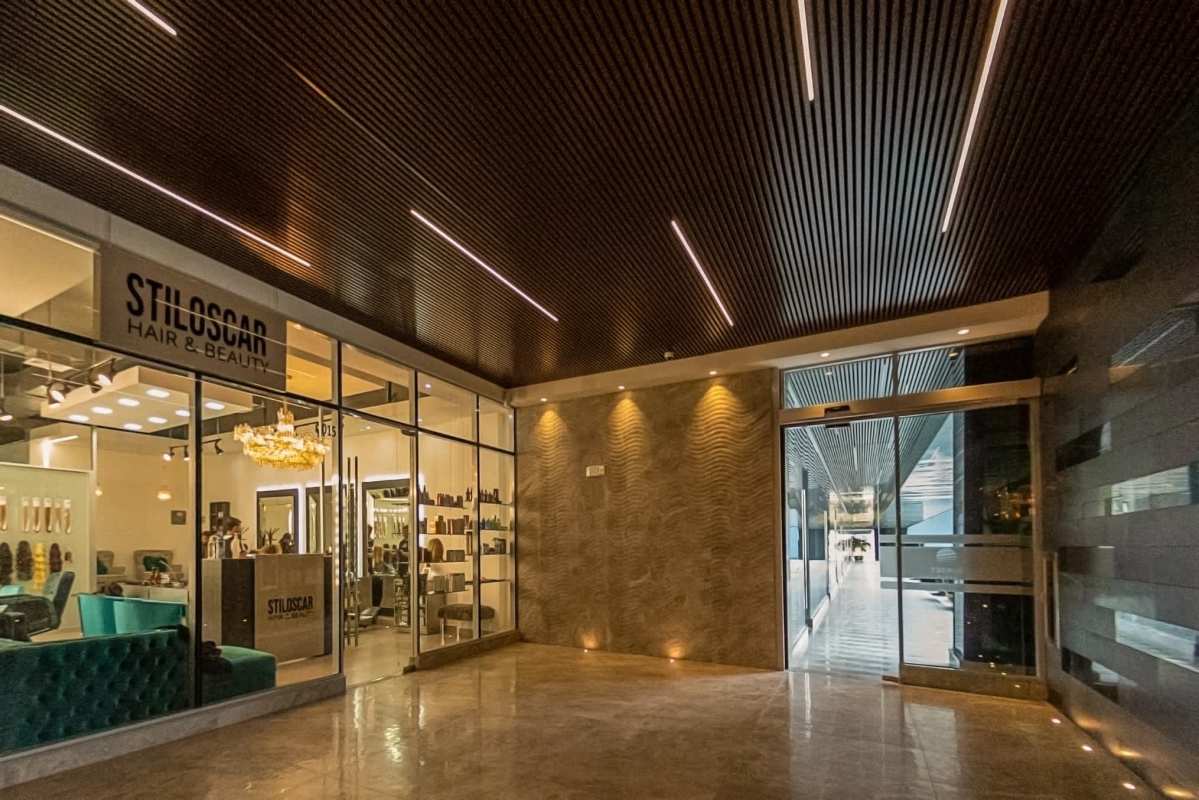 Glass-panel retail salon with turquoise sofa and modern lighting inside Sunset Strip Mall Panama