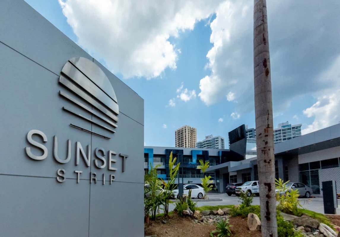 Wide angle exterior showing Sunset Strip commercial plaza and parking in San Francisco Panama