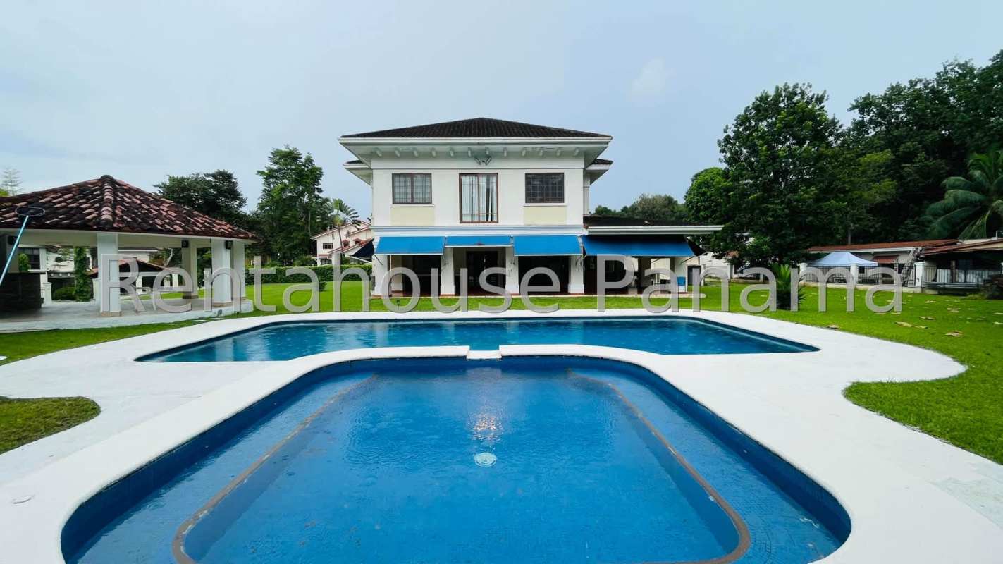 Exterior colonial house with blue awnings, swimming pool, green gardens at PH Camino de Cruces El Dorado Panama