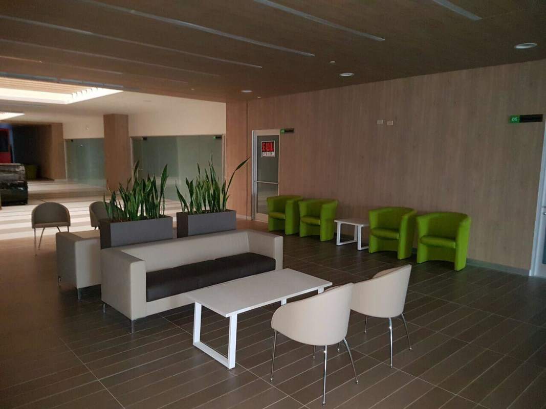 Lobby waiting area with indoor plants sofas and armchairs in Plaza Brisas Mall Panama City
