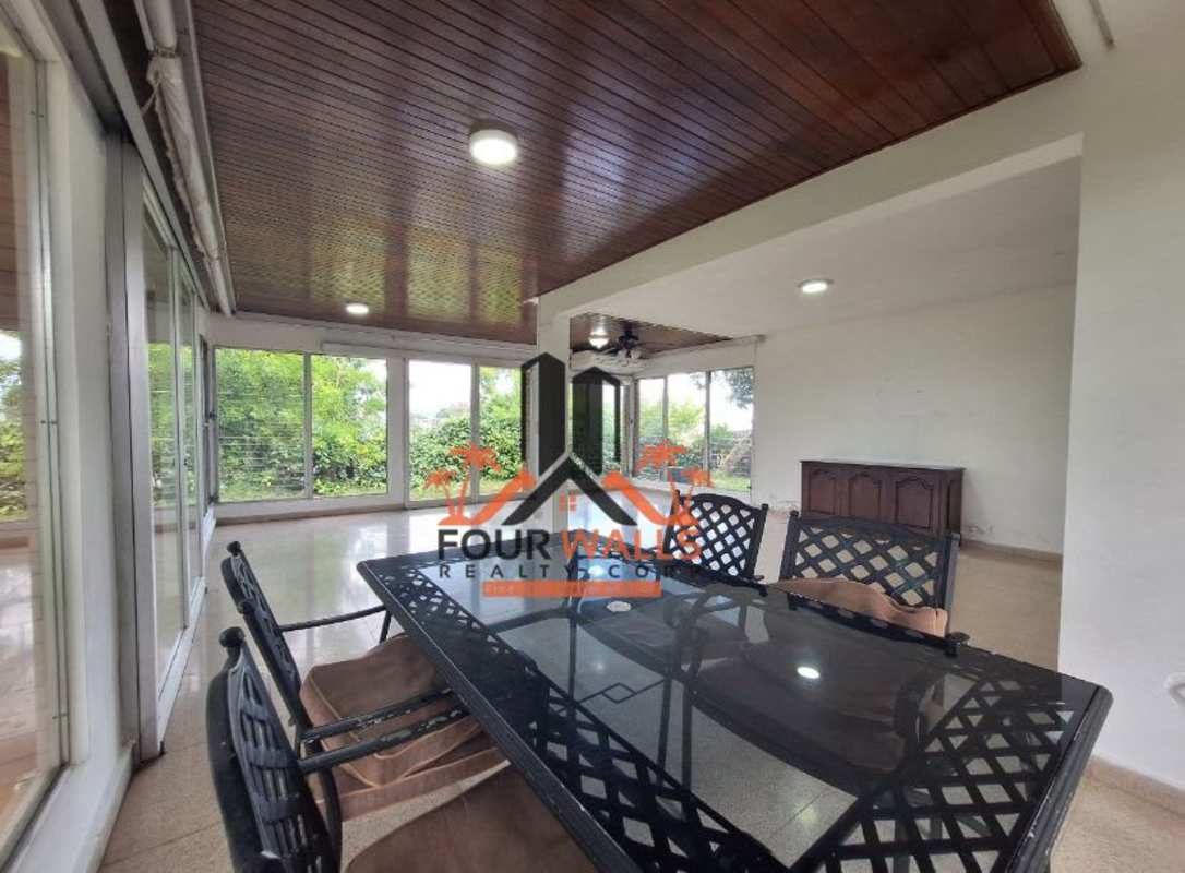 Bright dining space with modern furniture, floor to ceiling windows, garden view in El Dorado Panama City