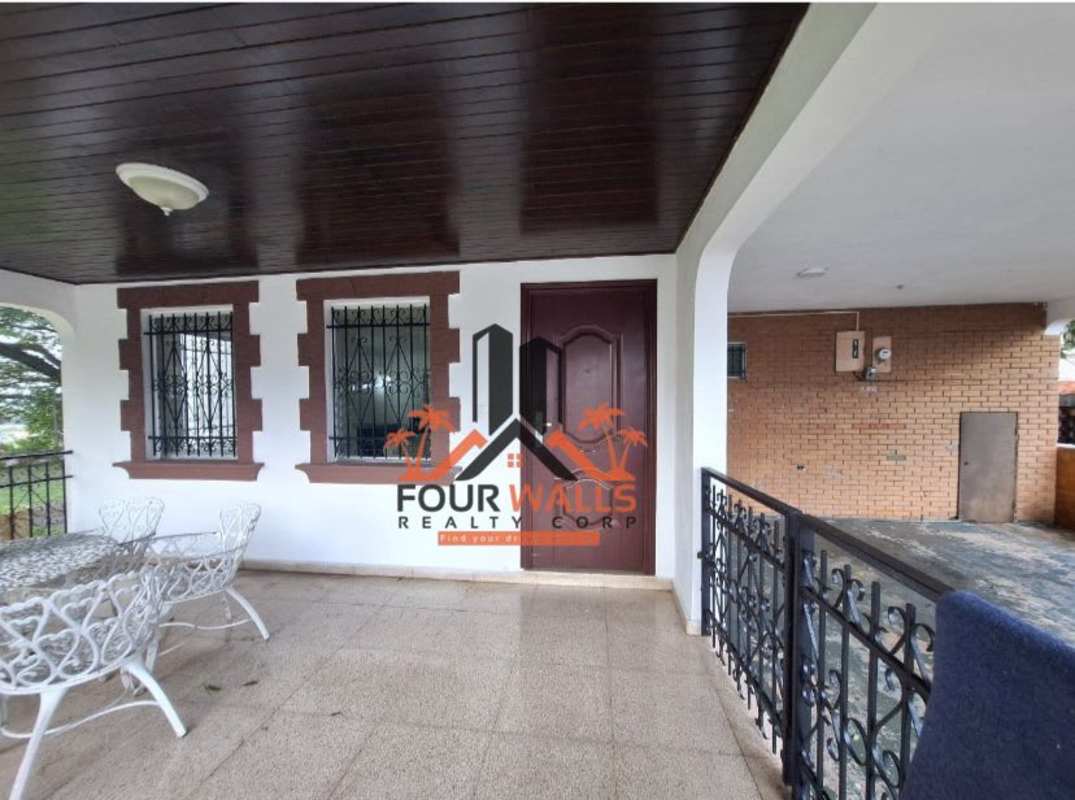 Patio with white metal furniture, brick columns, garden and driveway view in El Dorado Panama