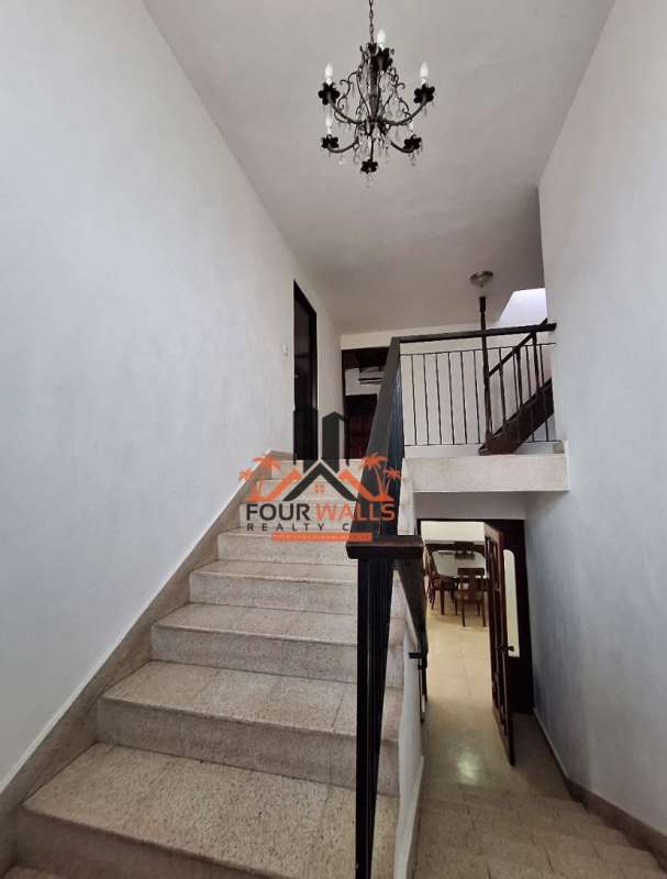 Elegant two-story Mediterranean house with balconies, carport, driveway, lush landscaping in Panama City