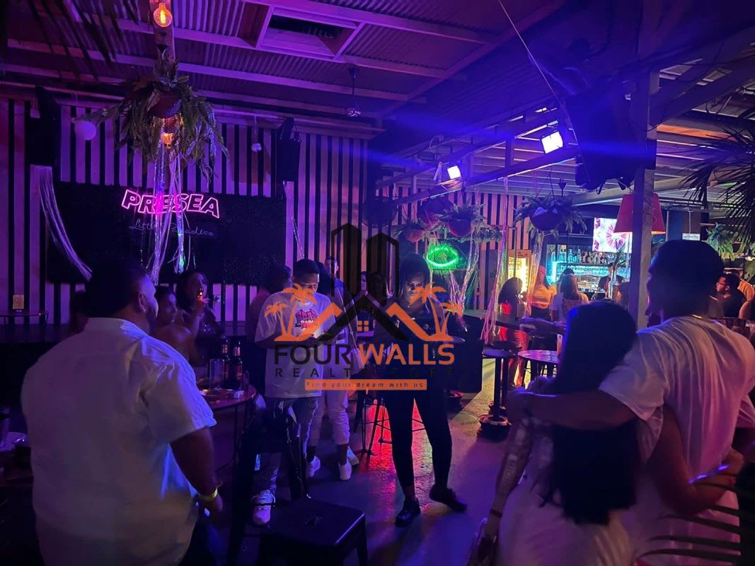 Lively nightlife bar with neon lighting, urban décor, hanging plants Panama City