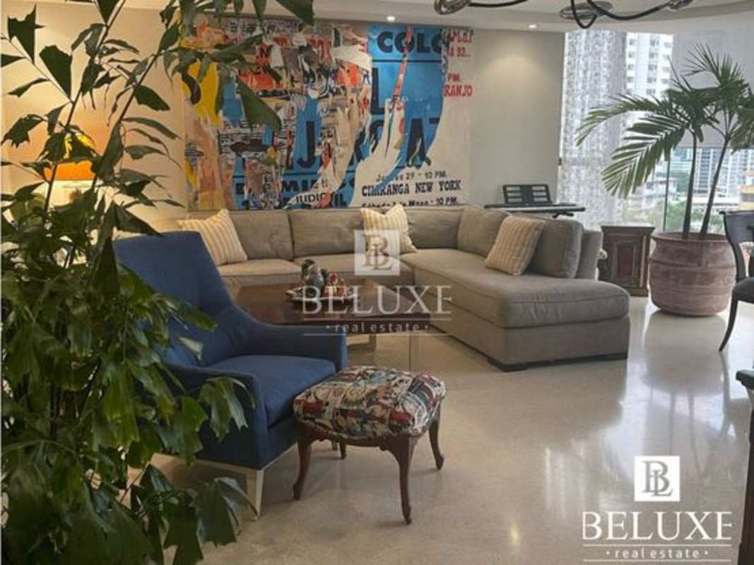 Bright lounge with sectional seating, modern artwork, large windows at Torre La Cresta Panama City