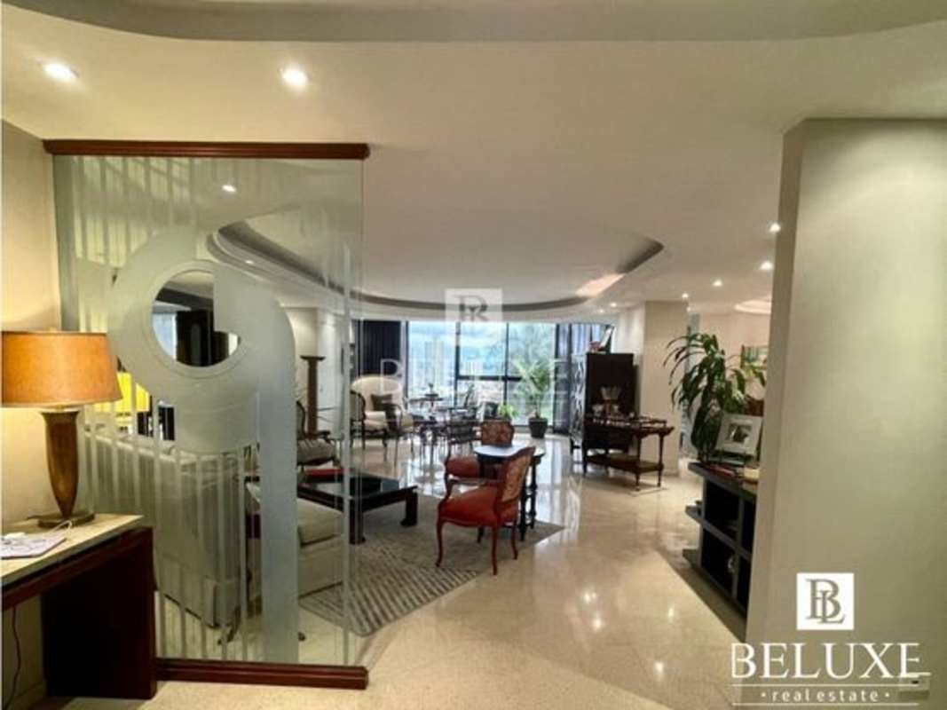 Contemporary living room with frosted glass panel, seating and city views at Torre La Cresta Panama City