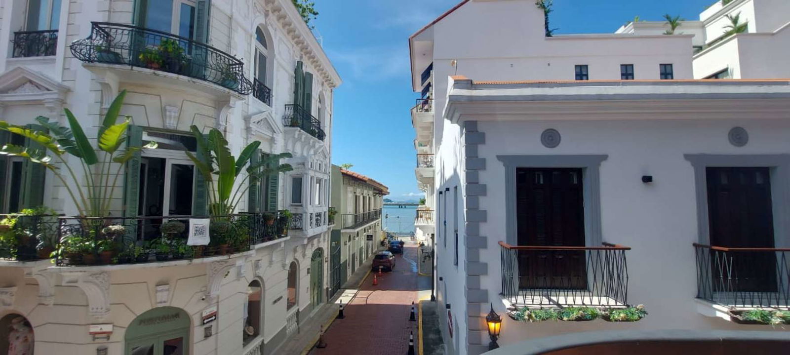 Colonial style entry with arched glass door, exposed stone and vibrant tile at Casco Viejo Panama