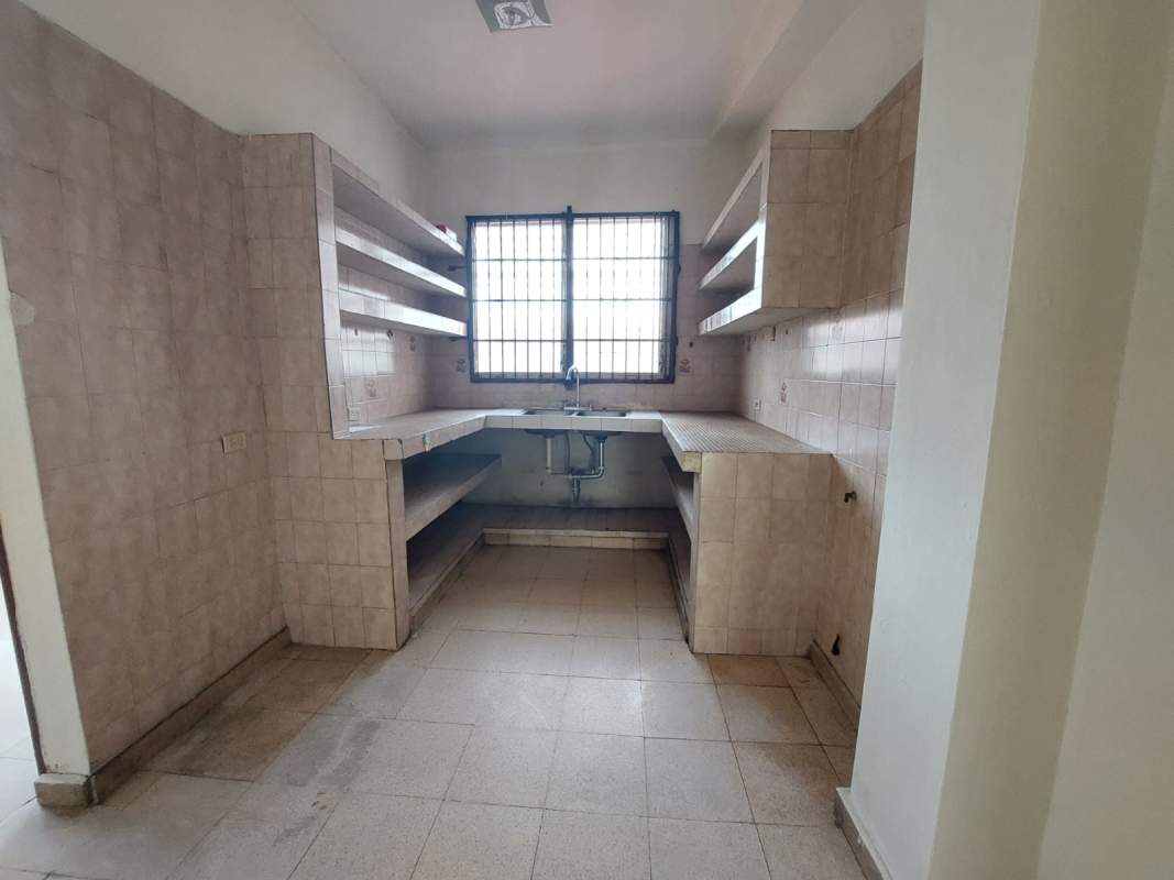 Simple tiled kitchen with double sink and open shelving in Panama City Juan Díaz apartment