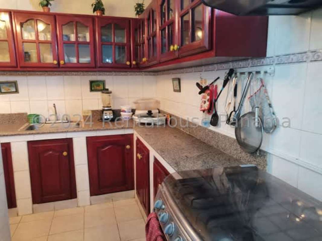 Traditional kitchen featuring granite countertops and wooden cabinetry in Don Bosco house Panama