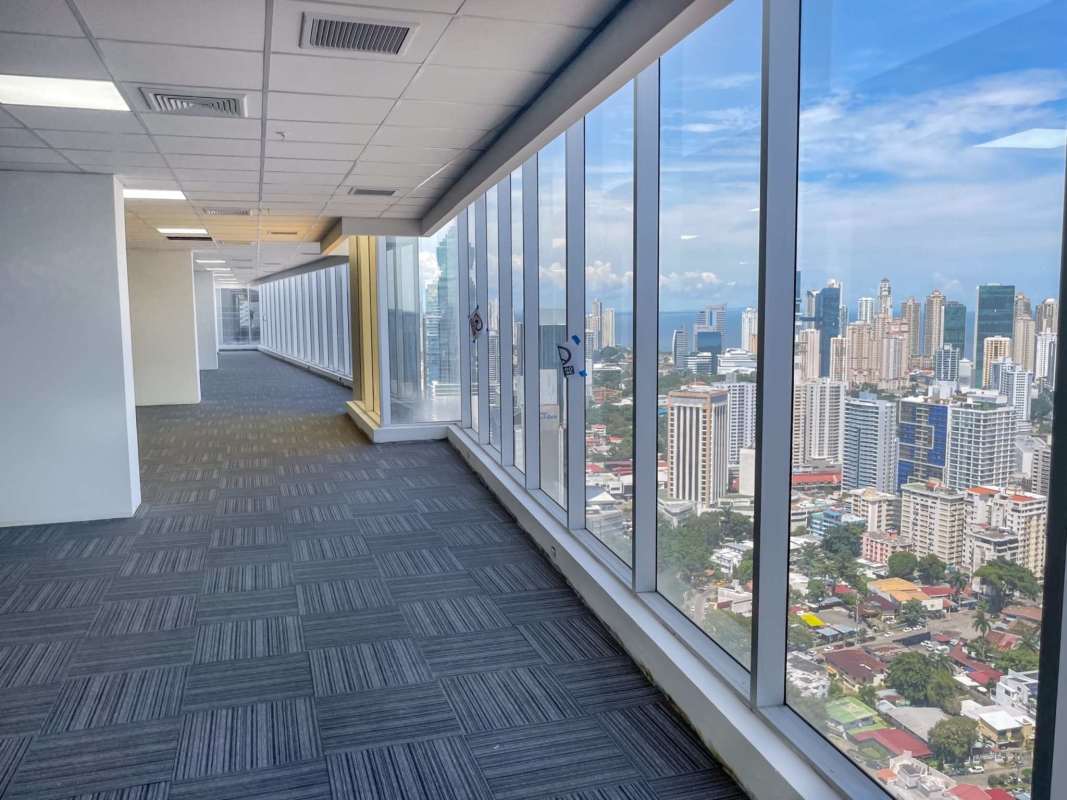 Empty office with floor-to-ceiling windows and glass-walled meeting room in Evolution Tower Panama