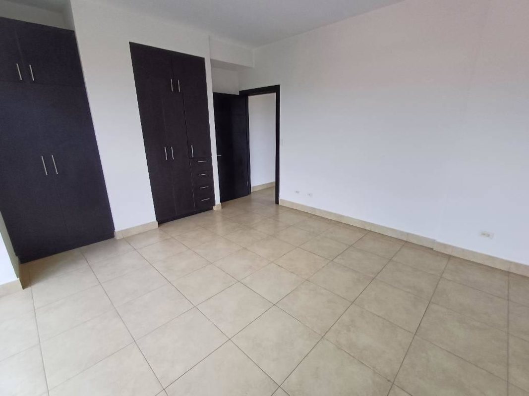 Bright bedroom with large window and built-in wardrobe at Amador Heights Panama