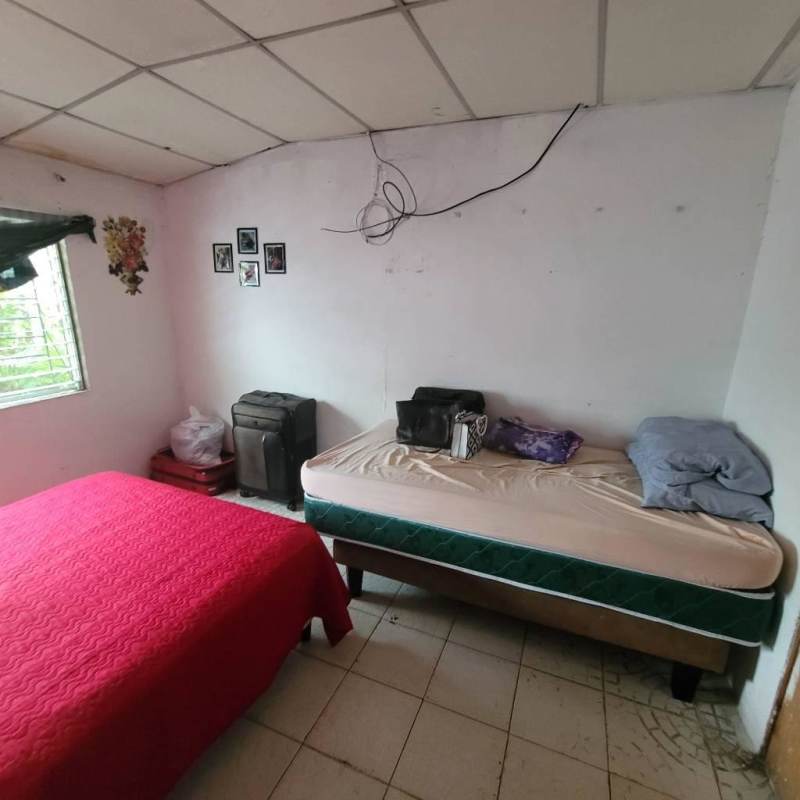 Minimal bedroom with bed and open wardrobe in Villa Guadalupe San Miguelito