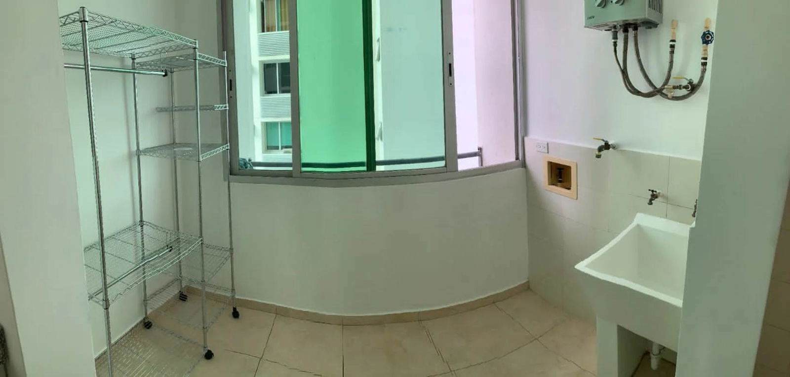Laundry room with utility sink, gas water heater and shelving in PH Sky Blue Panama City
