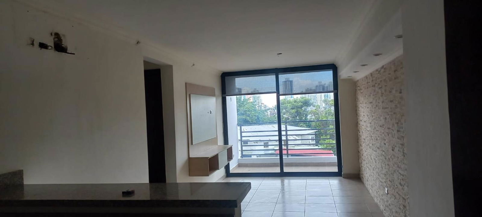 Living room modern with sliding glass balcony doors stone accent wall PH Vista Verde