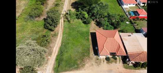 Aerial shot of 680 square meter residential land in El Guayabo with open yard and nearby homes