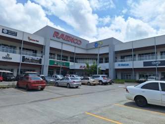 Two-story glass-fronted commercial plaza with ample parking at Costa Verde