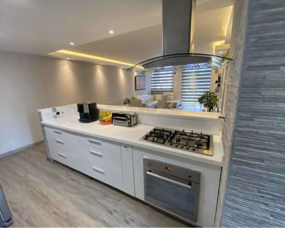 Open kitchen in PH Sunrise Tower featuring granite countertop, built-in oven, and gas stove