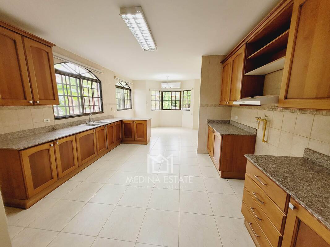 Large traditional kitchen with granite countertops, wooden cabinets, big windows in Clayton Village house