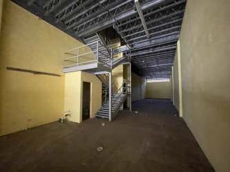 Open warehouse interior with metal stairs and mezzanine potential in Colon Free Zone