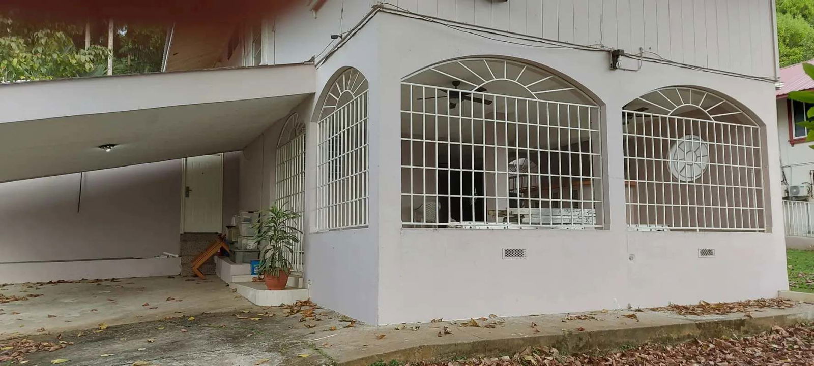 Tropical style exterior with covered carport secure windows lush yard Clayton Balboa Panama for sale