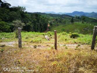 Open grassy field with distant tree-lined hills under blue skies in Santa Rosa Capira Panama