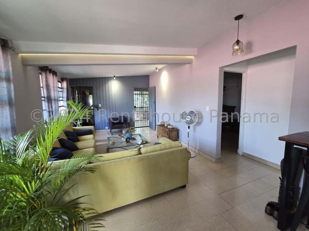 Functional traditional kitchen with gas stove, refrigerator, blue countertops, white cabinets in Panama house for sale