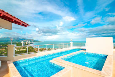 Open concept living dining area with floor-to-ceiling windows and panoramic ocean mountain golf views in PH Coronado Golf