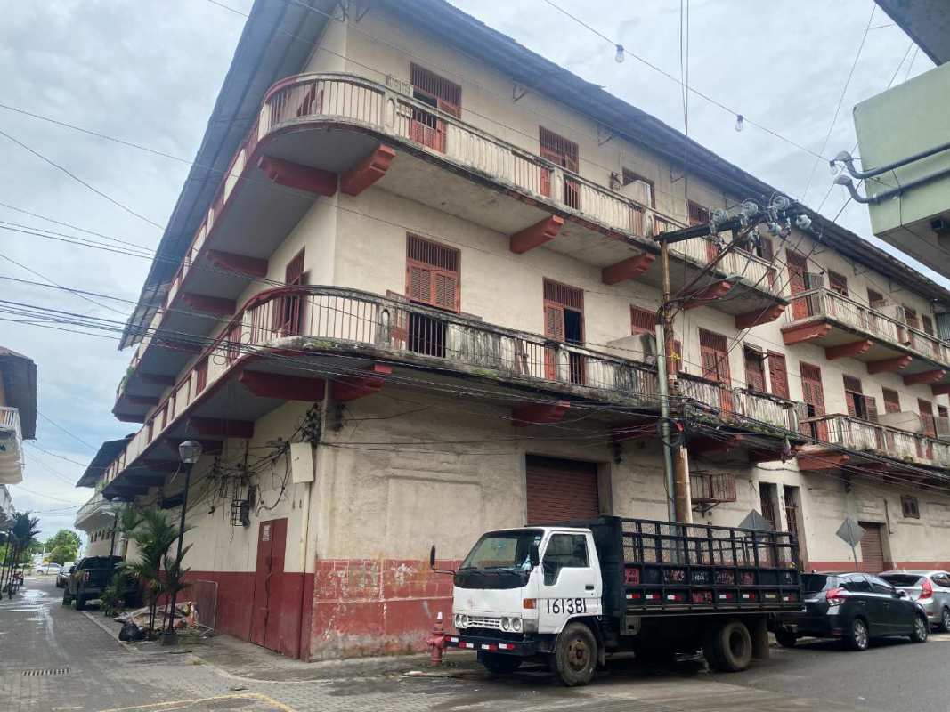Street corner view of colonial mixed-use building with balconies and commercial spaces Casco Viejo