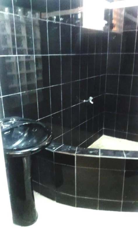 Modern bathroom with black tiles and black pedestal sink in Tierra Alta Villa Lucre house Panama
