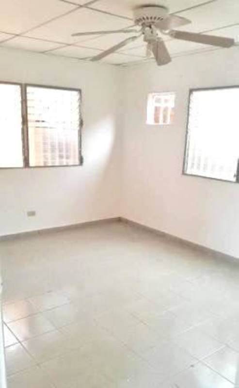 Bedroom with tile floors, ceiling fan, windows with security bars Villa Lucre Panama
