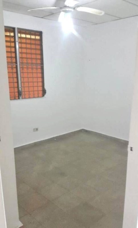 Simple bedroom with tiled floor, barred window, ceiling fan in Villa Lucre Panama