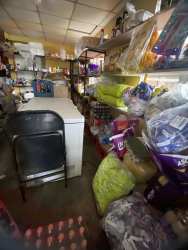 Informal roadside shop exterior with benches tables merchandise display shaded Bugaba David