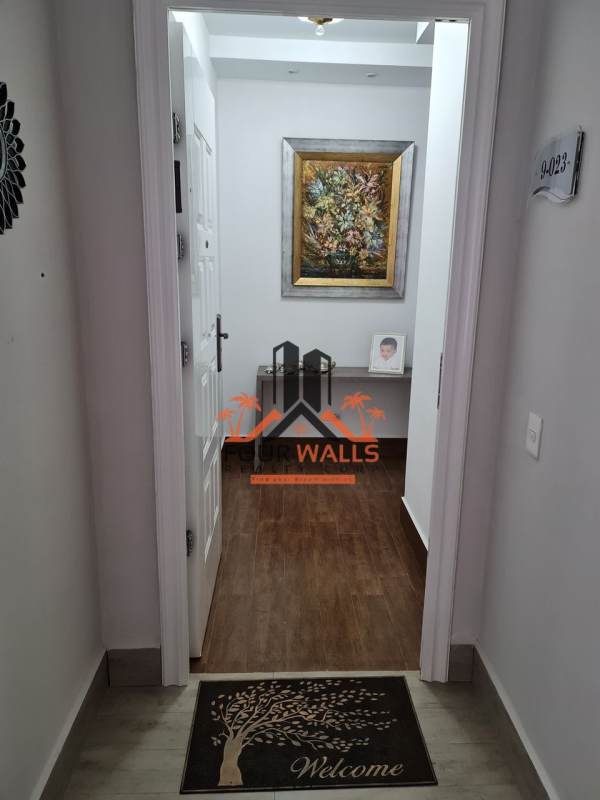 Bright hallway entrance with wood floors and art in PH Costamare Costa Sur Panama