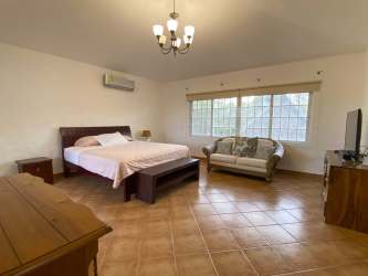 BBQ grilling area and landscaped garden beside pool Coronado Panama house